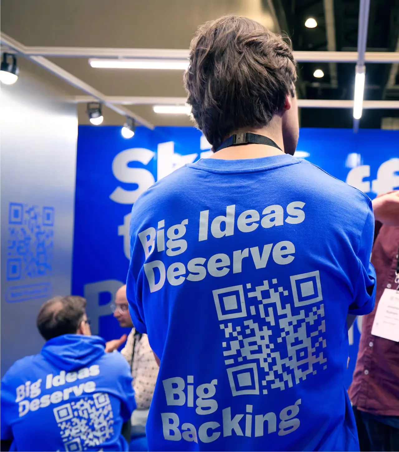 Conference attendee wearing a Big Ideas Deserve Big Backing t-shirt with QR code